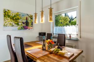 een eetkamer met een houten tafel en een raam bij Ferienwohnung Kuckucksnest in Lahr