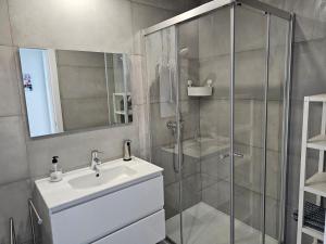 y baño con ducha acristalada y lavamanos. en Apartment Dona Vitória - Monte Gordo Beach, en Monte Gordo