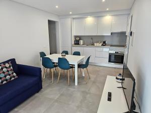 sala de estar con mesa y sofá azul en Apartment Dona Vitória - Monte Gordo Beach, en Monte Gordo