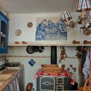 a kitchen with a stove with a picture on the wall at Casa da Muralha in Estremoz