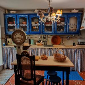 a kitchen with blue cabinets and a table with chairs at Casa da Muralha in Estremoz