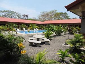 een binnenplaats met een picknicktafel en een zwembad bij Hotel D'Lucia - Quebrada Ganado, Jaco, Costa Rica in Puntarenas