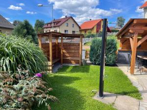 un giardino con cancello in legno e prato di Apartmán u Kovářů a Kašperské Hory