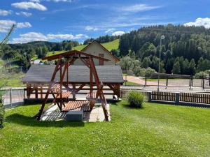 un parco con una panchina di legno nell'erba di Apartmán u Kovářů a Kašperské Hory