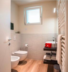 a bathroom with a white toilet and a sink at Monolocale Moderno Valpolicella Verona - Agni in San Pietro in Cariano