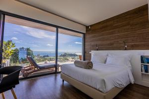 ein Schlafzimmer mit einem Bett und einem großen Fenster in der Unterkunft Quinta das Camélias - Açores in Ponta Delgada