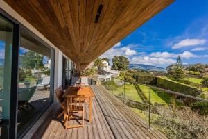 eine Holzterrasse mit einem Tisch und Stühlen auf dem Balkon in der Unterkunft Quinta das Camélias - Açores in Ponta Delgada