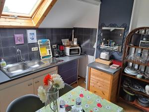 a small kitchen with a table and a sink at Claire de Meuse Cozy apartment Detox with river and hills in Anhée