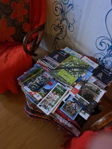 a pile of magazines on a table next to a bed at Claire de Meuse Cozy apartment Detox with river and hills in Anhée