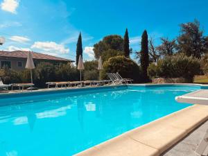 una gran piscina azul con sillas y sombrillas en Hotel Monti, en Lamporecchio