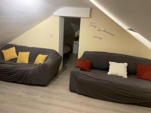 uma sala de estar com dois sofás de couro num sótão em Spacious apartment in Charleroi 100 m² with parking 5 ppl em Charleroi