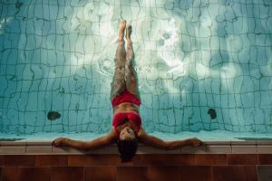 une personne flottant dans une piscine dans l'établissement Das gemütliche Dorfhotel Kaltenhauser, à Hollersbach im Pinzgau