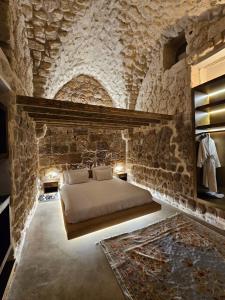 een slaapkamer met een bed in een stenen muur bij Akotika boutique in Akko