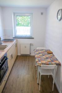 a kitchen with a table and chairs and a window at FeWo in Radekow 3 in Mescherin