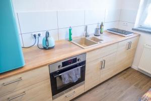 a kitchen with a sink and a stove at FeWo in Radekow 3 in Mescherin