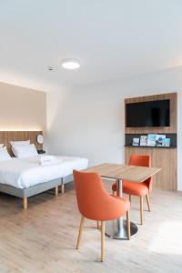 - une chambre avec un lit, une table et des chaises dans l'établissement Villa Thermae Nancy, à Nancy