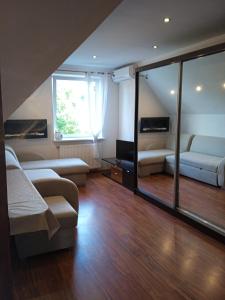 salon z kanapą, łóżkiem i oknem w obiekcie Apartament Mazurska 24a w mieście Kętrzyn