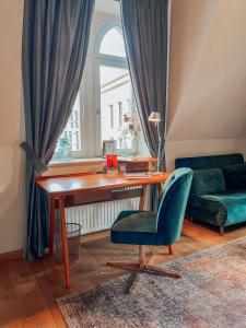 uma sala de estar com uma secretária e uma cadeira verde em Apartmenthaus am Dom "Maisonette" em Zwickau