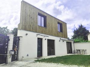 a white house with a wooden roof at Sara in Aulnay-sous-Bois