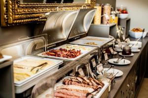 un buffet con varias bandejas de comida en una mesa en Hotel Sigulda, en Sigulda