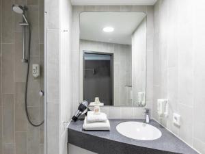 y baño con lavabo y ducha. en B&B Hotel Lübeck, en Lübeck