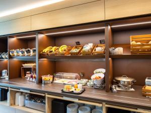 una cocina con comida en las estanterías de un restaurante en B&B Hotel Lübeck, en Lübeck