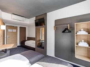 1 dormitorio con cama, escritorio y mesa en B&B Hotel Lübeck, en Lübeck