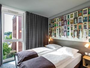 1 dormitorio con cama y ventana grande en B&B Hotel Lübeck, en Lübeck