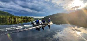 eine Gruppe von drei Personen in einem Boot auf einem Fluss in der Unterkunft Auberge Boréale de Charlevoix in Petit-Saguenay