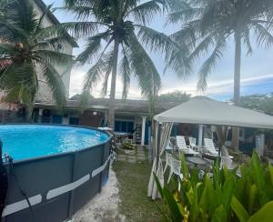 una casa con piscina e palme di Dar Yasmine Motel a Pantai Cenang