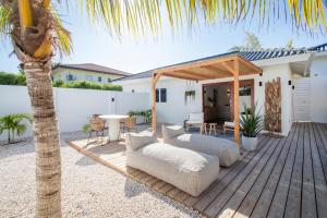 une terrasse en bois avec un canapé et une table dans l'établissement Appartement James, à Jan Thiel