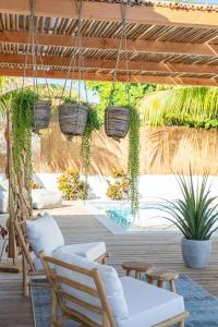 d'une terrasse avec des chaises et des paniers suspendus. dans l'établissement Appartement James, à Jan Thiel