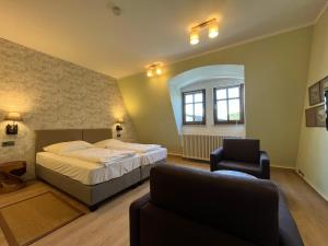 une chambre d'hôtel avec un lit et une chaise dans l'établissement Hotel Liszt, à Weimar