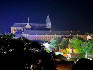 duży budynek z wieżą zegarową w nocy w obiekcie La Touratte Bed & Breakfast w mieście Saint-Hubert