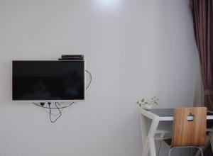 uma televisão de ecrã plano pendurada numa parede branca em Guangzhou Uhome Service Apartment em Guangzhou