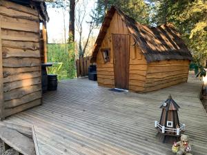 una terraza de madera con una pequeña casa de madera en La Vallée De Taradeau, en Taradeau