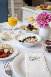 - une table blanche avec des assiettes de nourriture et de boissons dans l'établissement Hotel Ilmenautal inklusive THERMEplus, à Bad Bevensen