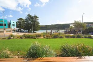 un parco con prato e bacino d'acqua di Loch Ard Motor Inn a Port Campbell