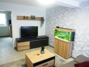 ein Wohnzimmer mit einem Aquarium und einem TV in der Unterkunft Ferienwohnung Familie Mergner in Bad Langensalza