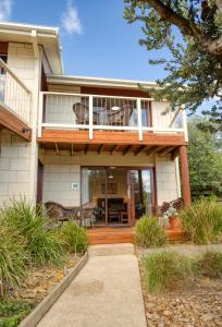 una casa con portico e terrazza con patio di Loch Ard Motor Inn a Port Campbell