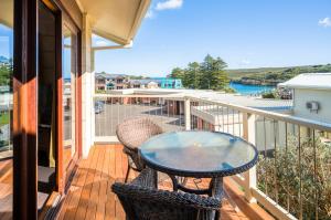 un patio con tavolo e sedie sul balcone. di Loch Ard Motor Inn a Port Campbell