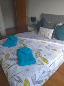 een bed met blauwe kussens erop bij Fistral beach apartment in Newquay