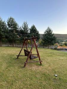 een houten schommel in een grasveld bij Готель Едельвейс in Skhidnitsa