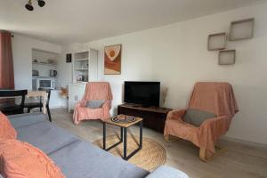 a living room with a couch and chairs and a tv at Gîte NO 9 in Neufchâteau