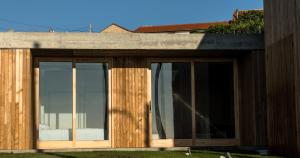 une maison avec portes coulissantes en verre dans une cour dans l'établissement Doniños Nature, à La Corogne