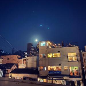 un edificio alto por la noche con luces encendidas en ROUTE - Cafe and Petit Hostel, en Nagasaki