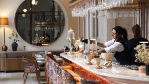 twee vrouwen achter een bar in een restaurant bij Convent Square Lisbon, Vignette Collection by IHG in Lissabon