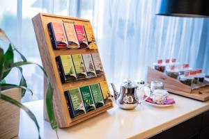 ein Regal mit Büchern auf dem Tisch. in der Unterkunft Apart Hotel Legendär in Steindorf am Ossiacher See