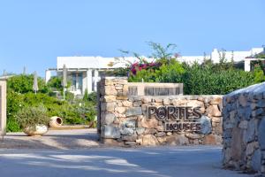 een stenen muur met een huisbord erop bij Portes Houses in Koufonisia