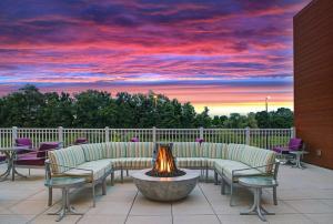 een patio met stoelen en een vuurplaats met een zonsondergang bij Hilton Garden Inn Manassas in Manassas